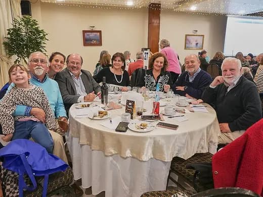 Socias y socios compartiendo en una mesa durante un bingo.
