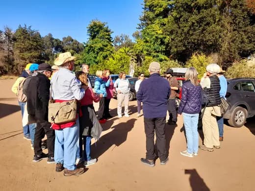 Grupo de socios reunidos al aire libre en un asado.