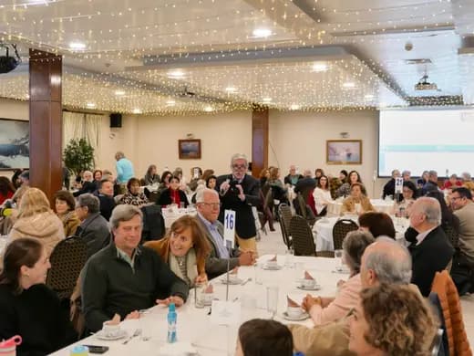 Salón decorado con mesas servidas durante una cena de la corporación.