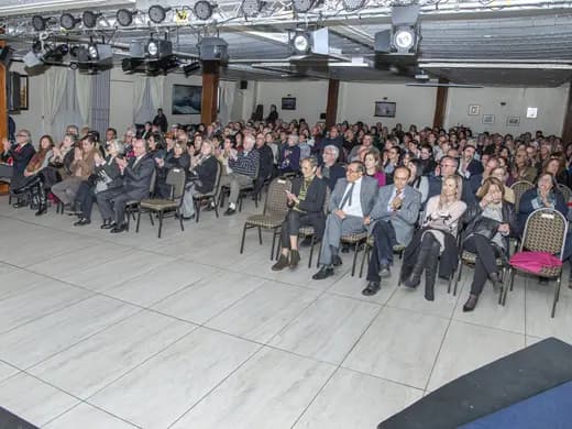 Salón lleno de asistentes en una charla de la corporación.